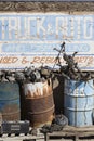 Sign And Rusty Barrels In Junkyard