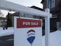 Sign for sale in front of a detached house in residential area. Royalty Free Stock Photo