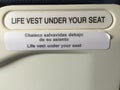 Sign saying life vest under your seat