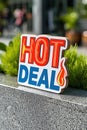 A sign that says hot deal on a ledge in front of some plants, AI Royalty Free Stock Photo