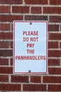 Sign that says please do not pay the panhandlers posted on brick wall - close-up Royalty Free Stock Photo