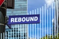 An sign that says rebound on a post and a blended bar chart trending upward.