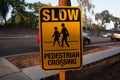 Sign says SLOW PEDESTRIAN CROSSING on the street of Los Angels, America. Street signs means the traffic rule, advertising, or many