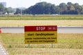 Sign at Schiphol Amsterdam Airport with Stop - Start and landin strip in dutch language