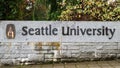 Sign for Seattle University in black letters on rock wall