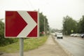 Sign sharp turn. Red road sign. Arrow pointer on road Royalty Free Stock Photo