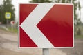 Sign sharp turn. Red road sign. Arrow pointer on road Royalty Free Stock Photo