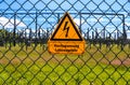 Sign showing the words high voltage in german language at the fence of a big substation distributing electric energy with lots Royalty Free Stock Photo