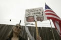 A sign shows President Bush and VP Cheney as the devil with the US Flag at an anti-Iraq War protest march in Santa Barbara