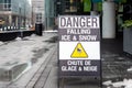 Sign on the sidewalk warning of the danger of ice and snow falling from the above Royalty Free Stock Photo