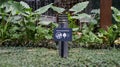 A sign and a small illustration for not to step on the plant, in a beautiful garden with waterfall and tropical plant at the Royalty Free Stock Photo