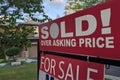 Sign sold over asking price for sale in front of detached house in residential area Royalty Free Stock Photo