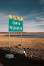 Sign in Spanish: Dangerous bend in a desert landscape in Peru. Royalty Free Stock Photo