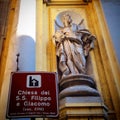 A sign and a statue in front of St.Philip and Jecop`s church Naple, Italy