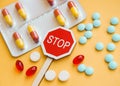 Sign Stop drugs. Colorful pile of medicines and painkillers on yellow background Royalty Free Stock Photo