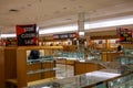 Sign for a store closing sale on top of an empty jewelry display case with empty illuminated shelves.