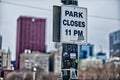 Sign on the street light saying that park closes in 11 PM