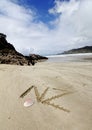 Sign symbolizing New Zealand written in the sand on an idyllic beach