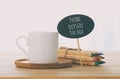 sign with text: THINK OUTSIDE THE BOX next to cup of coffee over wooden table.