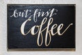 Sign on textured plaster kitchen wall - But first Coffee - Painted in cursive on blackboard surface