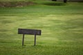 A sign on top of a lush green field