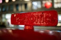 A sign on top of a traditional British Red Post Box pointing towards a post office