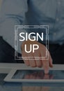 Sign up text and graphic against close up of hand touching tablet and dark overlay