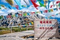 Sign and view of the 4500m high Shika snow mountain summit with prayer flags in Shangri-La Yunnan China