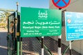 Sign with visiting time all ingresso di Hawiyat Najm Sink hole park, in english and arabic language.