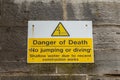 A sign on a wall near the sea warning of the dangers of jumping in the sea and that there is a danger of death Royalty Free Stock Photo