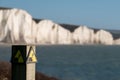 Sign warning of the danger of erosion at the cliff edge overlooking Seven Sisters at Seaford in East Sussex, south coast of UK Royalty Free Stock Photo