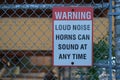 Sign warning loud noise horns can sound at any time on the fence at port. Royalty Free Stock Photo