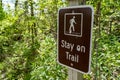Sign warning and reminding hikers to stay on the trail Royalty Free Stock Photo