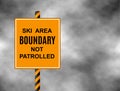A sign warning skiers and snowboarders that the are they are about to enter is out of bounds and not patrolled. Border text ski ar