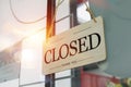 Sign wooden closed hanging on front glass door of cafe.