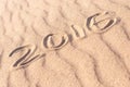 Sign 2016 written on sandy beach. Summer travel concept