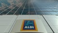 Signage board with Aldi logo. Modern office building facade. Editorial 3D rendering