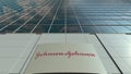 Signage board with Johnson and Johnson logo. Modern office building facade. Editorial 3D rendering