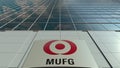 Signage board with MUFG logo. Modern office building facade. Editorial 3D rendering