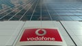 Signage board with Vodafone logo. Modern office building facade. Editorial 3D rendering