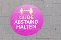 Signage keep distande Abstand halten at the floor of a pedestrian promenade in Ruedesheim