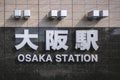 Signage of Osaka JR station in front of the train station building.