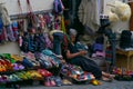 SIGNAGHI, GEORGIA - JULY 6, 2019: Georgian woman sits and sells on street national rugs and knitted socks