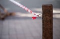 Signal red-white tape tied to a hook on a wooden pole Royalty Free Stock Photo