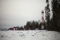 Signal tower in field in winter. Industrial landscape. Warning beacon for air transport Royalty Free Stock Photo