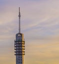 Signal transmitting tower with a colorful sky full of clouds, telecommunication technology and architecture