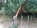 Signaling on a wooden stake on a rural road. Wooden barrier of prohibited passage on the footpath. Beaconing signs. Trekking and