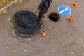 signalman worker pulling an electric cable through the city well