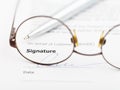 Signature of agreement and pen through eyeglasses Royalty Free Stock Photo