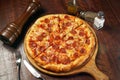 Signature Pepperonis Special Pizza isolated on cutting board top view on table italian fastfood Royalty Free Stock Photo